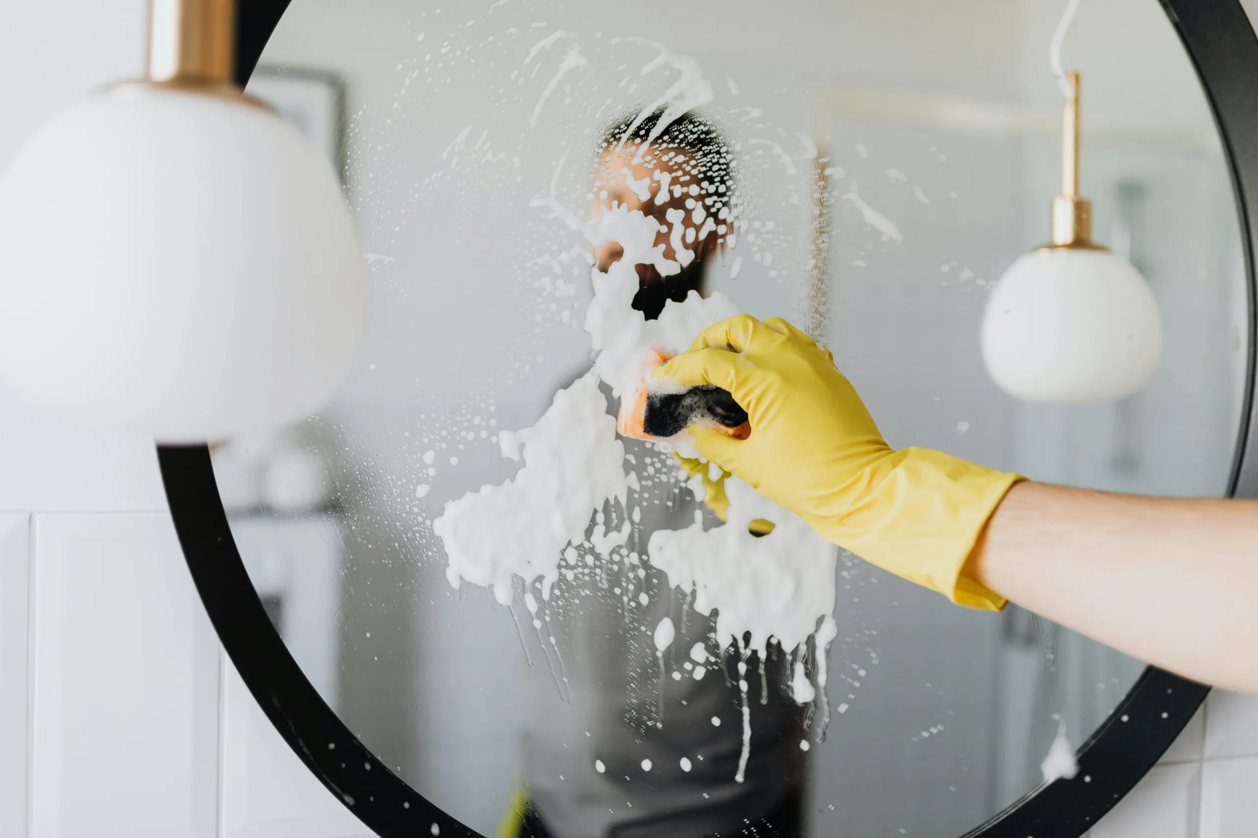 rubber gloved hand holding a spray bottle